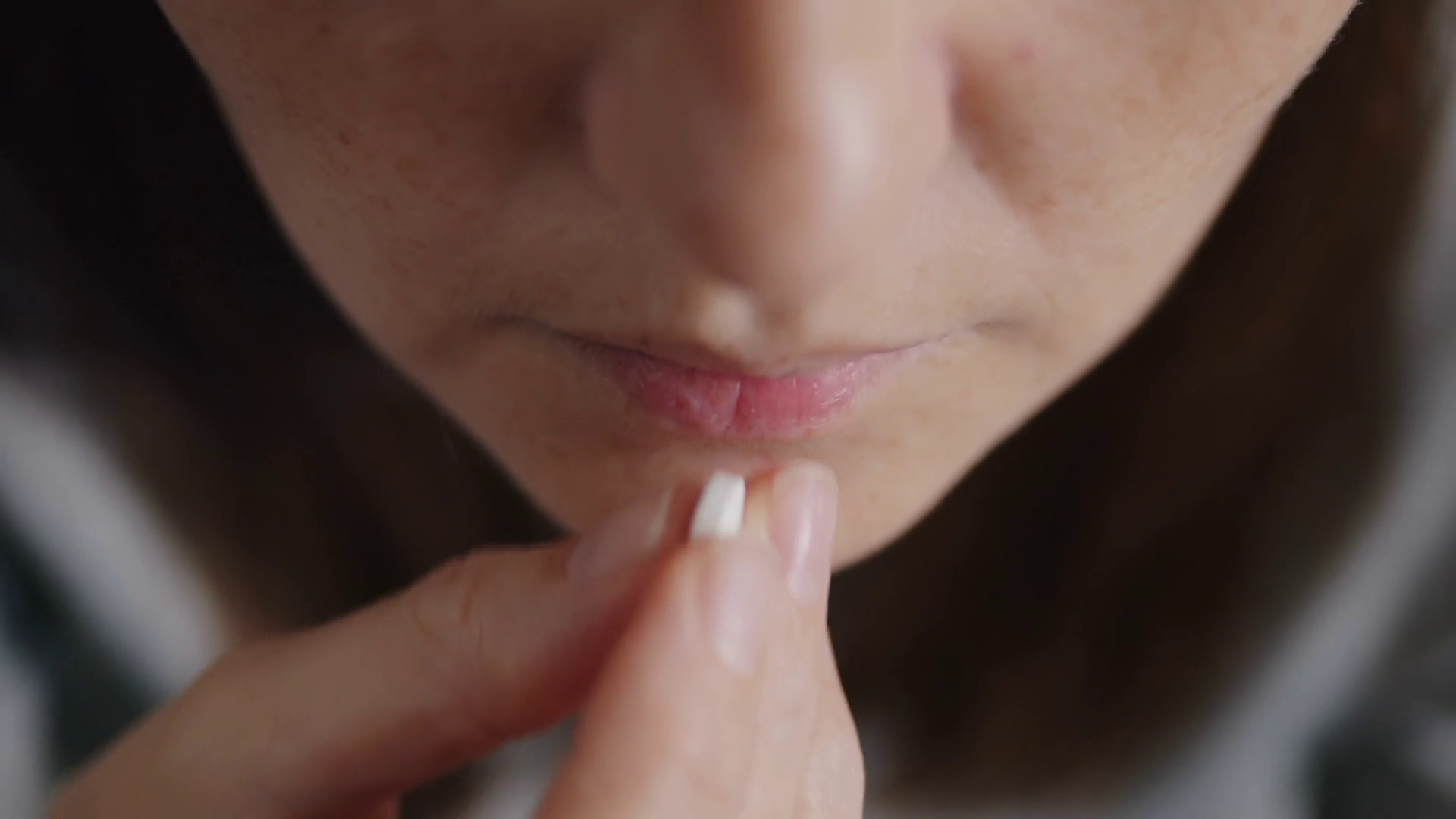close up of a woman taking a white zinc pill and drinking water Stock
