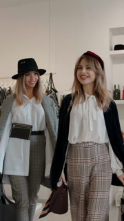 Vertical of Happy female shoppers with shopping bags leaving fashion store. | High Quality Visual