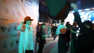 4K UHD footage of paparazzi photographers working hard near the press wall with bright flashes and cameras using softbox. Orange color and background. Smile happiness. handy shooting