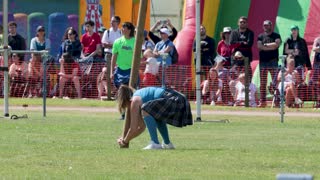 Woman Competing in Caber Toss at Highland Games Event