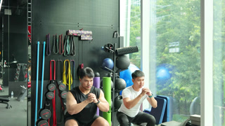 Personal Trainer Guides Squat Exercise in Bangkok Gym