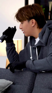 Burglar in Hoodie and Gloves Searching a Living Room with Flashlight