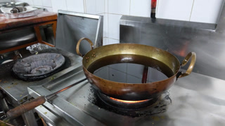 Brass Wok Heating Oil on Commercial Gas Stove Burner