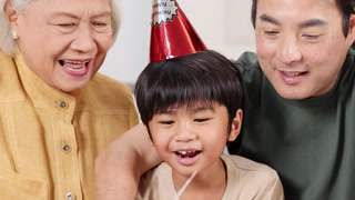 Close Up of Multigenerational Asian Family Celebrating a Birthday Together