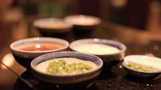 Close-Up of Asian Sauces in Ceramic Bowls on Restaurant Table