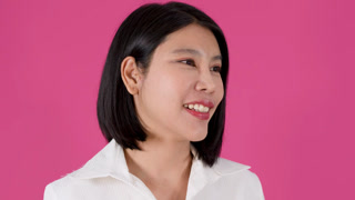 Asian Woman with Short Black Hair Speaking and Smiling Against Pink Background