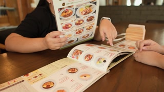 Diners Selecting Dishes From Restaurant Menu in Bangkok