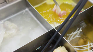 Dipping Meat and Vegetables into Boiling Chinese Hot Pot Soup Bases
