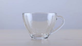 Fresh Water Pouring into a Clear Glass Cup on Wooden Table