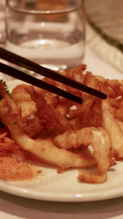 Vertical Close-Up of Chopsticks Picking Up Crispy Fried Fish