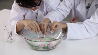 Children in Lab Coats Conduct Science Experiment with Milk and Food Coloring