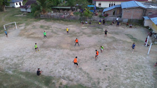 Aerial View of People Playing Soccer on Rural Field
