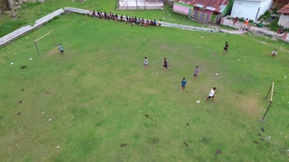 Aerial View of Boys Playing Soccer on a Rural Field