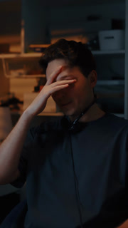 Frustrated man taking off headphones while reacting emotionally at computer