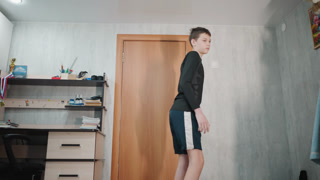 Caucasian grandson closing wooden bedroom door and walking away, confident stride down corridor, carrying small backpack, evening light