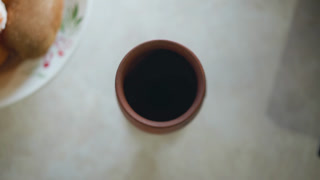 Overhead coffee cup and bread plate, home cook morning ritual with warm ceramic mug, soft sunlight, textured tabletop, cozy rustic