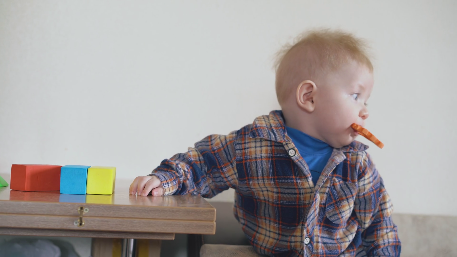 Funny Little Boy Nibbles Orange Toy Leaning Stock Footage SBV347404282