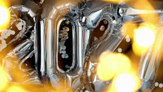 Holiday bokeh garland Happy new year 2027 metallic balloons with confetti on dark black background. Greeting card silver foil balloons