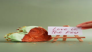 LOVE IS THE KEY text on paper note. Morning card Valentines day gift present Heart shaped pistachio croissant on green background with copy