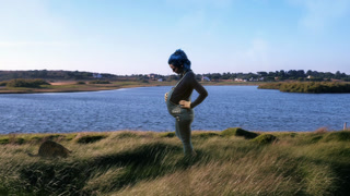 Pregnant Woman Standing On Lake Side With Cat