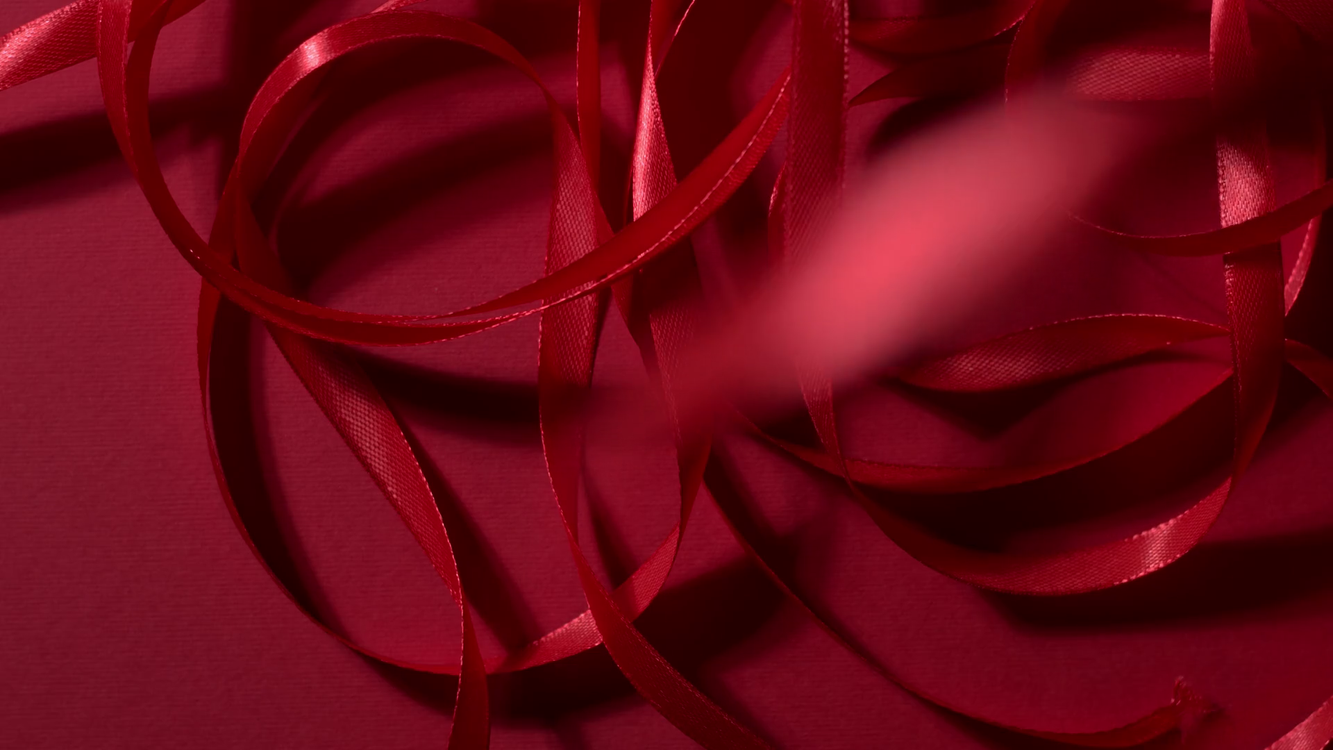 Dark Red Silk Glossy Ribbon Is Falling Down On Matte Deep Cherry Red Surface Atmospheric Video Background New Year Christmas St Valentine Festive Mood 4k Still High Quality Top Shot Video Footage