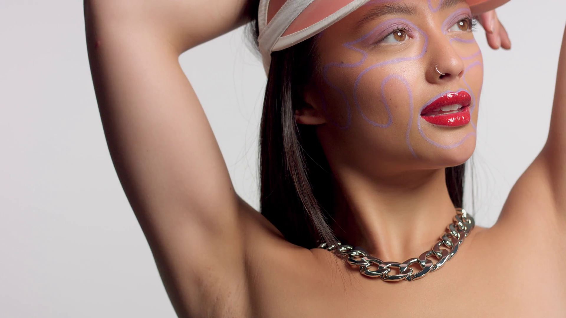 mixed race asian model in studio creative art makeup with hands up