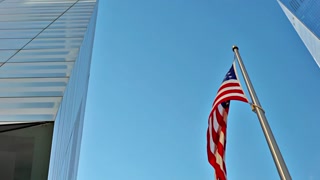 American flag waving proudly with one world trade center in the background view