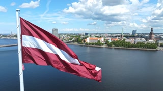 Latvian flag with the Dome Cathedral and an old town in the background in Riga, Latvia, the Baltic countries