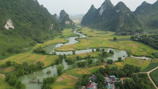 Aerial View of Winding River Through Rice Terraces and Karst Mountains in Cao Bang, Vietnam