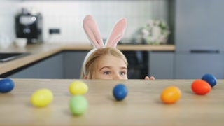 Blonde little boy in bunny ears getting ready for Easter holiday, having fun at home. Cute mae kid playing before easter. Funny child play