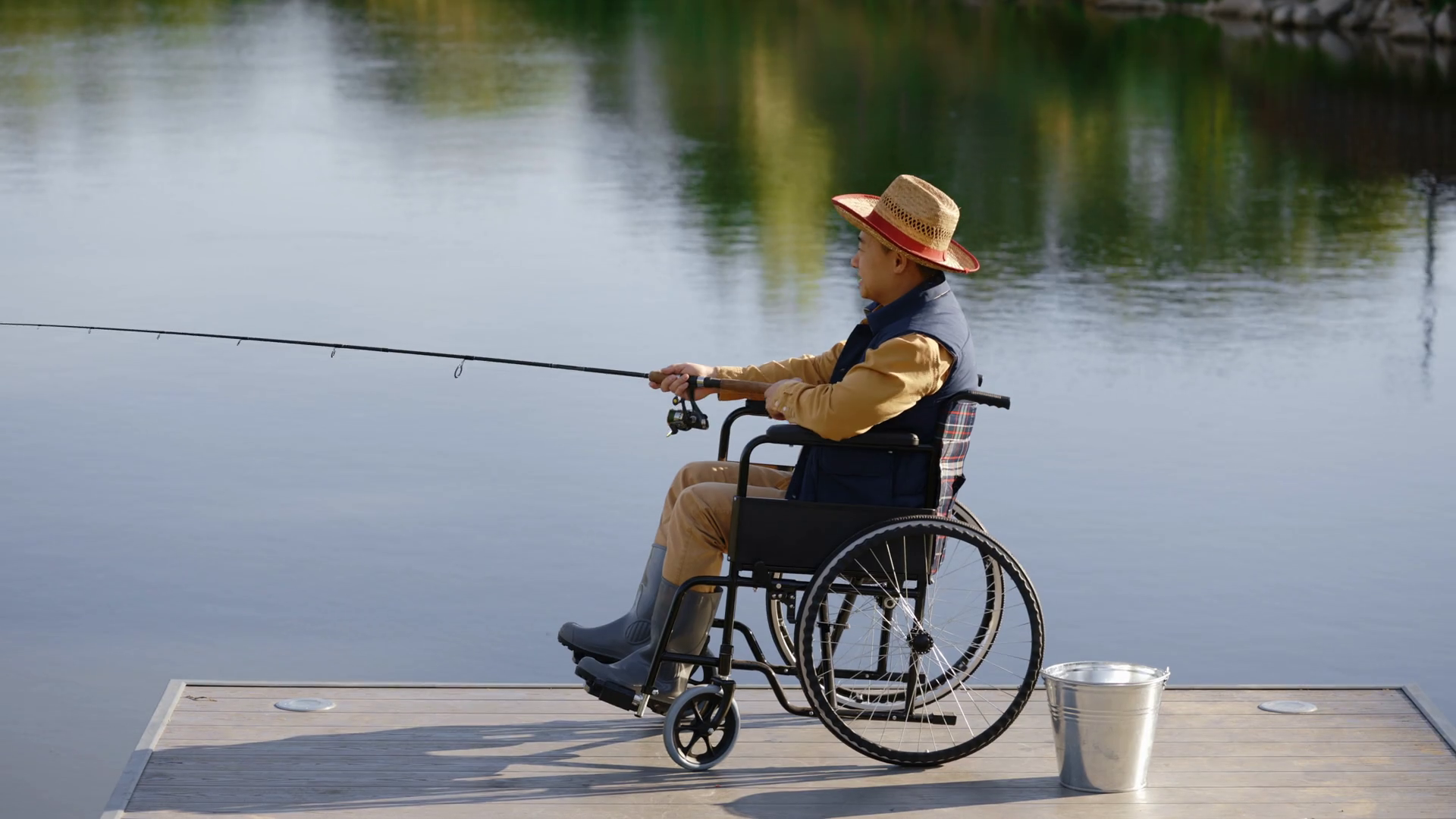 Side view of the disabled asian man wearing hat and special fishing