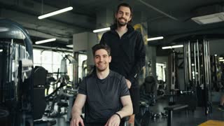 Inspiring Wheelchair Fitness Journey: Smiling Duo Poses and Motivates in the Gym for Inclusion and Empowerment