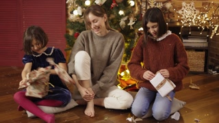 Excited individuals with family unpacking holiday gifts