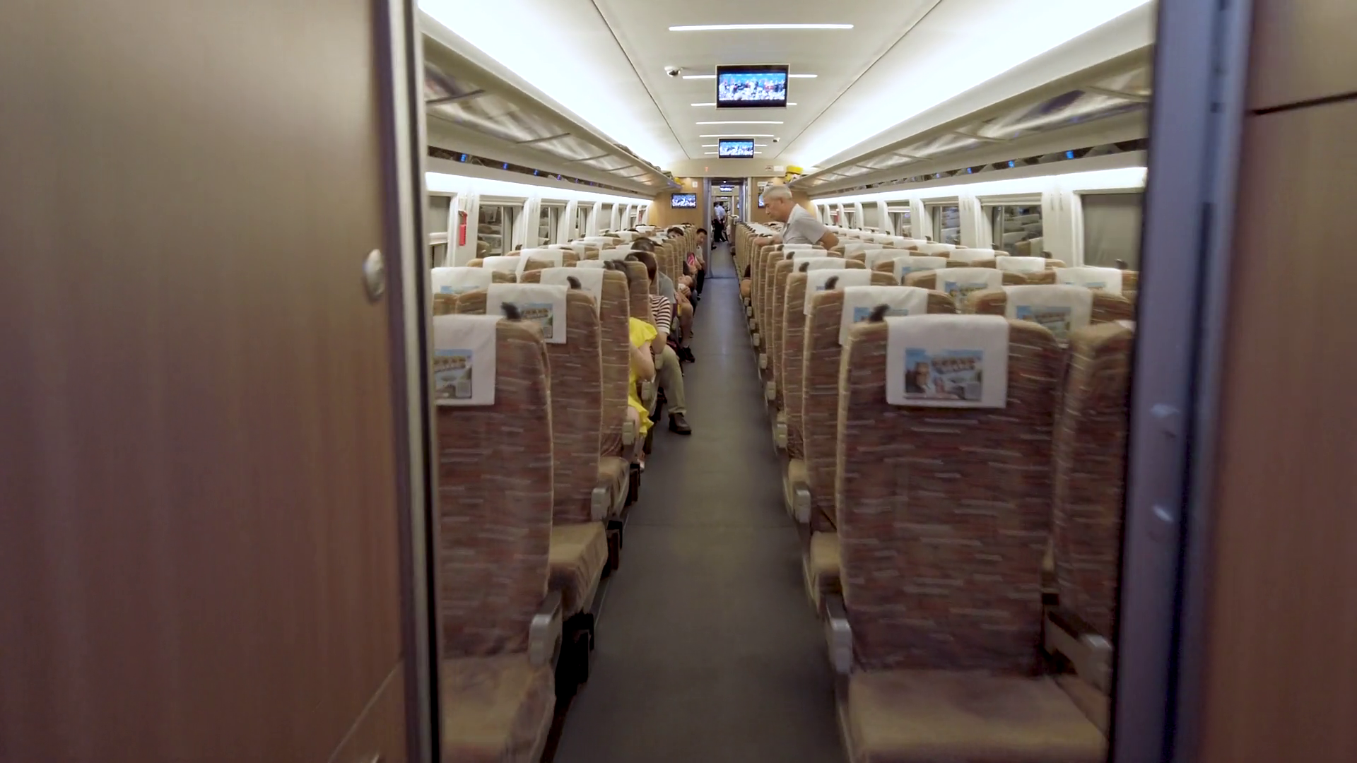 Fast moving through aisle of Chinese high speed rail car.Passengers