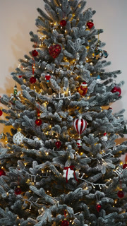 Vertical video decorated frosted Christmas tree with vintage ornaments and sparkling fairy lights slow motion mobile format family holiday stock footage