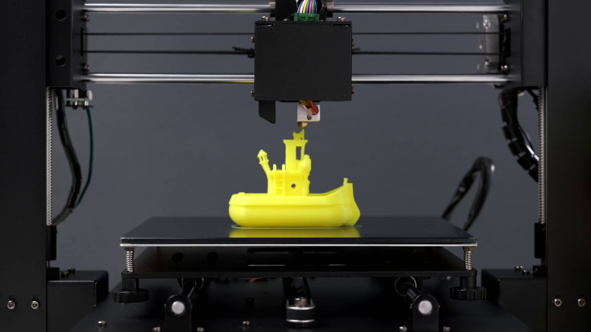 Printing on 3D printer figurines ship yellow plastic closeup. Clear