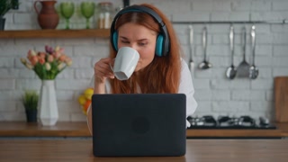 female studying from home or have a break drinking coffee watching video on laptop Online remote study, internet education technology concept