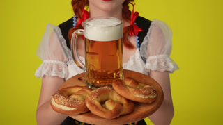 Close Up Yellow Background Isolated Video of an Unrecognizable Young German Woman Waitress Wearing a. Close up yellow background isolated video of an unrecognizable young German woman, waitress wearing a traditional costume, holding a platter with pr