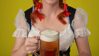 Close Up Yellow Background Isolated Video of an Unrecognizable Young German Woman Waitress Wearing a. Close up yellow background isolated video of an unrecognizable young German woman, waitress wearing a traditional costume, holding a platter with pr