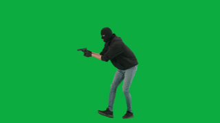 Portrait of Thief on Chroma Key Green Screen Background Man Robber with Stolen Bag Walks Got Caught. This full shot depicts a thief in a black mask standing on a green screen.
