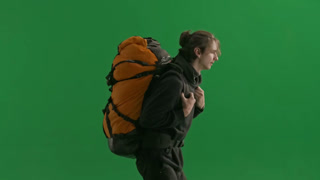 Side View of a Running Man Hiker with a Backpack on His Back Hurrying Tourist in Studio on Green. Side view of a running man hiker with a backpack on his back. Hurrying tourist in studio on green screen. Last moment for rush hiking and vacation