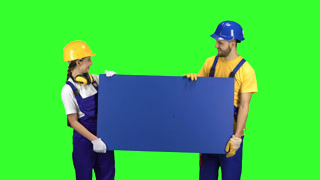 Worker in Overalls and Helmet Holds Sign WC and Shows Direction with His Finger
