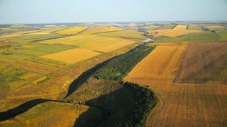 Aerial drone view of nature in Moldova. Valley with green hill slopes, fields, water in the distance