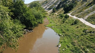 Aerial drone view of a valley with floating river, hill slopes and greenery around in Moldova