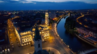 Areal drone view of the Unirii Square in Oradea downtown at night, Romania. Saint Ladislaus Church and Town Hall, illumination