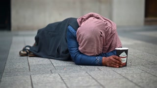 A homeless woman begging on the street