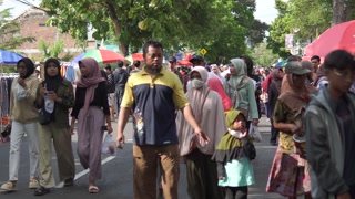 Klaten, Indonesia - December 13, 2024: Crowded and lively street with people walking on a Car Free Day, enjoying the outdoors and socializing.