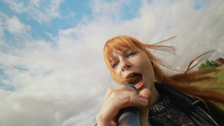 Portrait of young adult Caucasian female singer holding microphone and singing outdoors. Clip suitable for indie music production and youth festival marketing campaigns