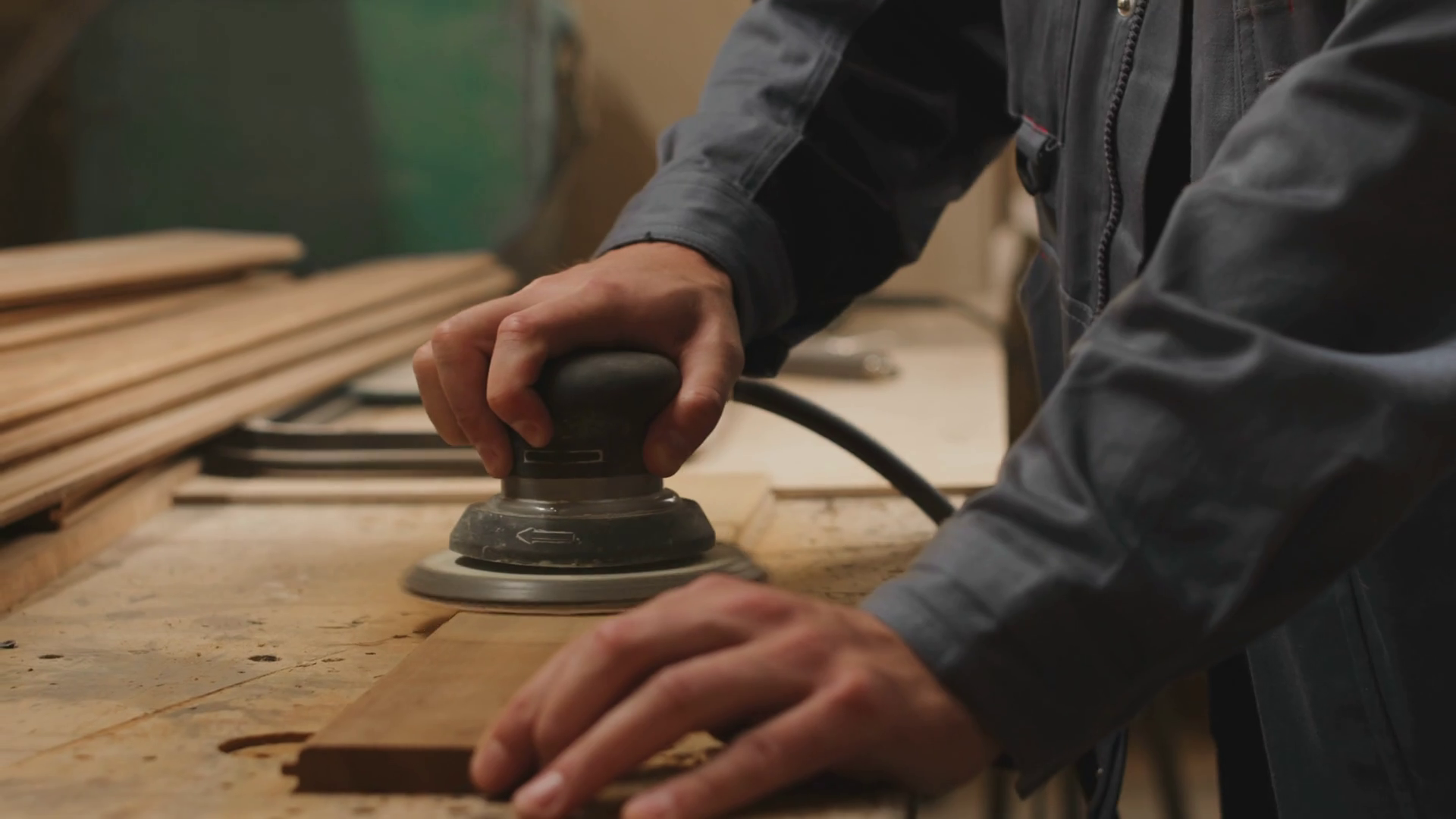Slowmo closeup of unrecognizable joiner polishing wooden planks with