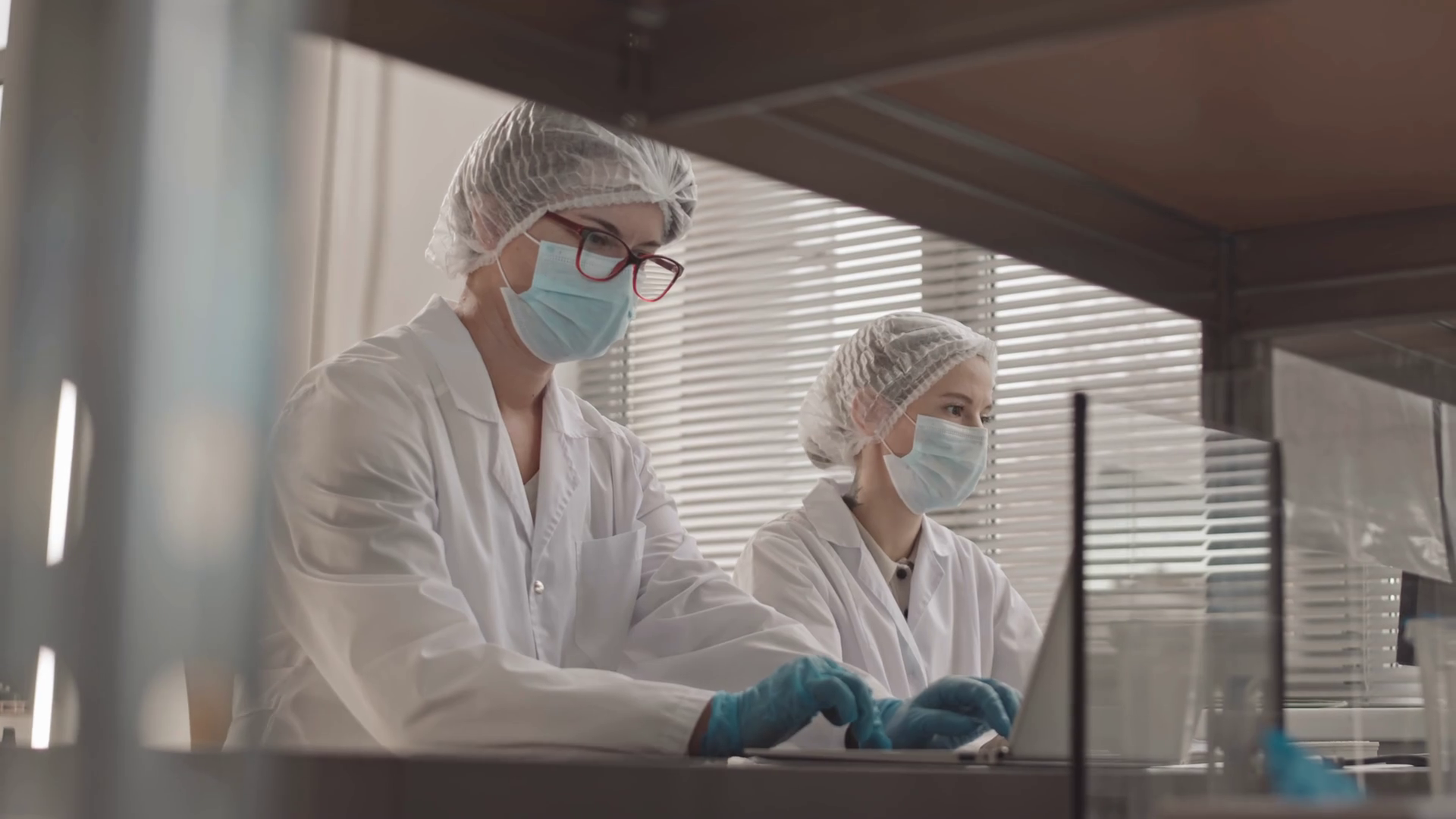 Low angle of two female Caucasian laboratory assistants wearing medical